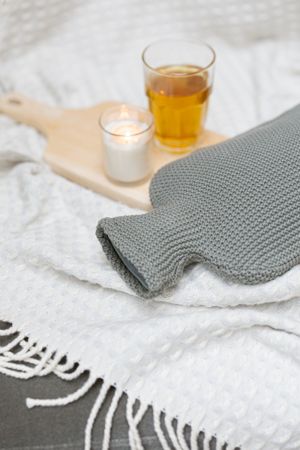 Hot water bottle with a knitted cover, rubber and organic cotton