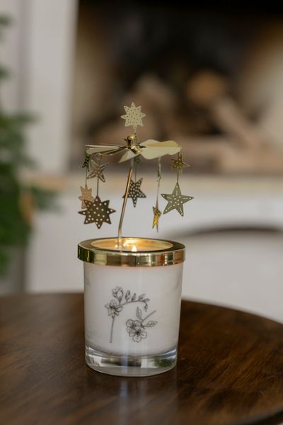 Rotating, metal mill with hanging stars for scented candles