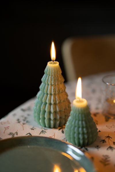 Large, dark-green ribbed Christmas tree-shaped candle